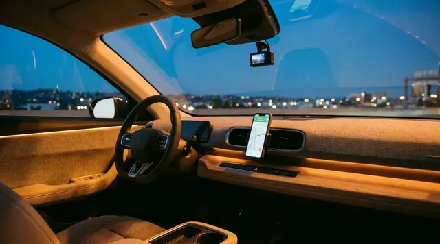 EV dashboard with phone mount and dash camera at dusk